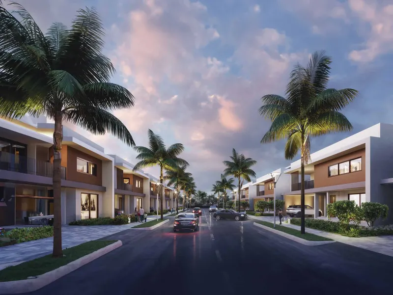 Row of Adarsh Welkin Park villas along a palm-lined internal road at dusk